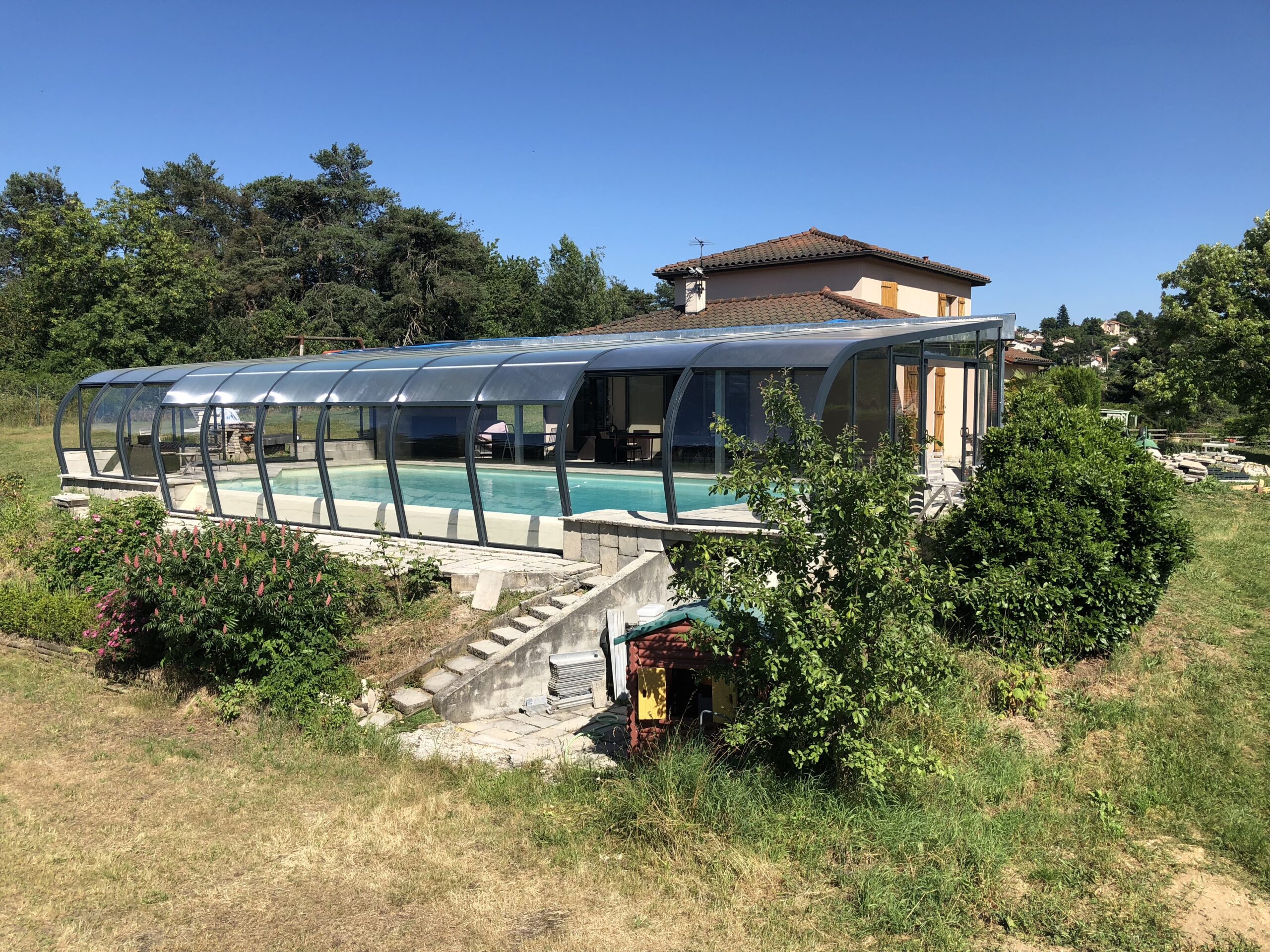 Abri piscine adossé intégré harmonieusement à la façade de la maison