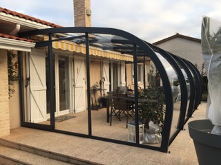 Abri terrasse adossé aluminium contre mur maison moderne