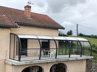 Structure adossée en aluminium protégeant une terrasse